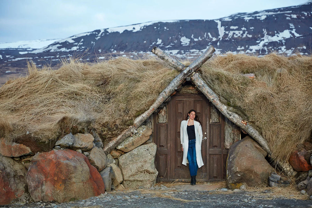 Meredith Lusk standing at the traditional Icelandic turf hut